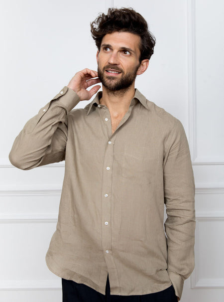 Man wearing a tan long sleeved shirt with pocket detail made with 100% linen in a Thomas Mason fabric.